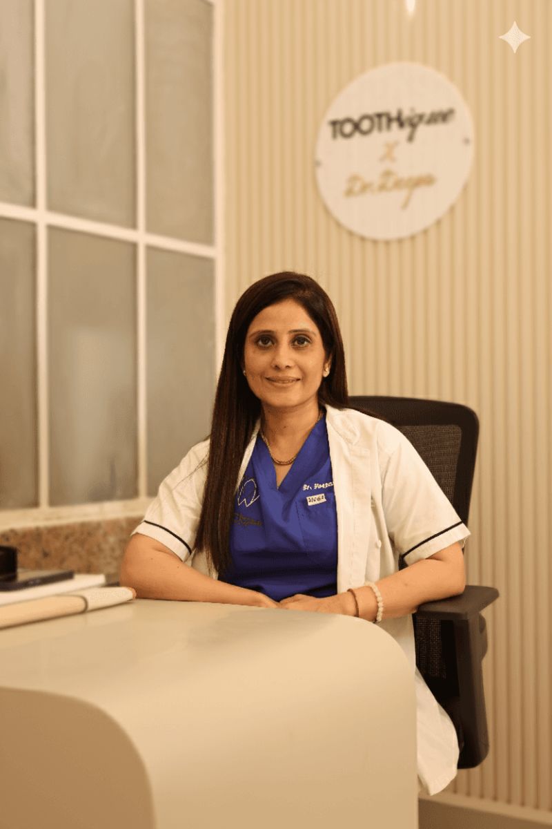 Dr. Deepa Sadhnani in her white coat at the Toothique consultation desk